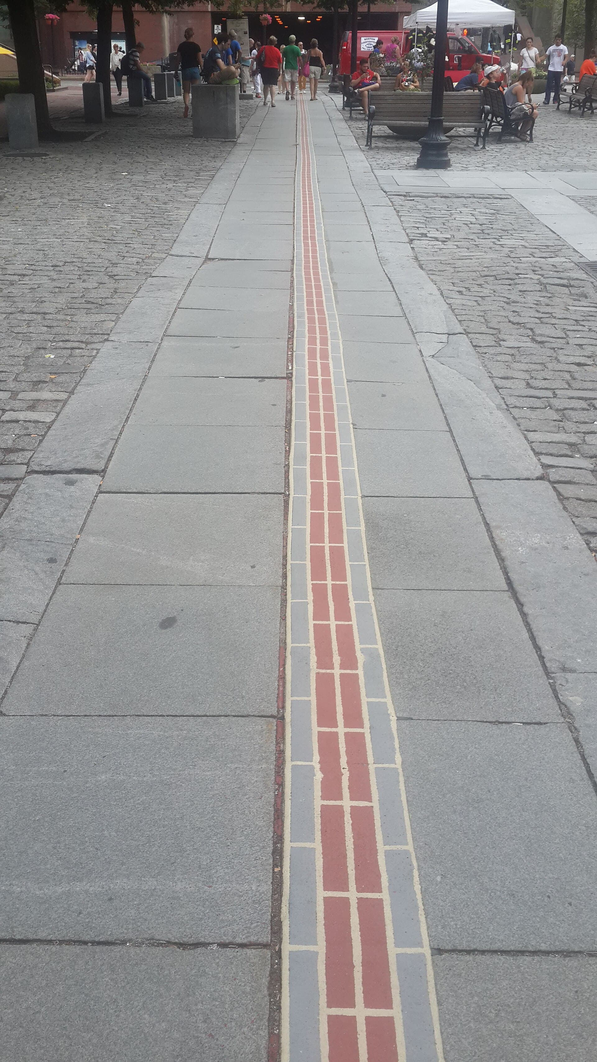 Red-brick Freedom Trail line crossing a Boston street
